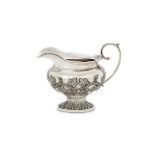 AN INDIAN COLONIAL SILVER OVAL PEDESTAL MILK JUG