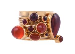 WENDY RAMSHAW CBE, AN 18 CARAT GOLD, GARNET AND FIRE OPAL ELEVEN RING STACK, LONDON 1987