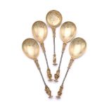 A SET OF FOUR CAST SILVER AND SILVER GILT APOSTLE SPOONS AND A SIFTING SPOON