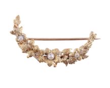 A GOLD COLOURED FLORAL CRESCENT BROOCH