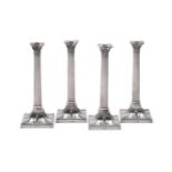 A SET OF FOUR ELECTRO-PLATED CORINTHIAN CANDLESTICKS