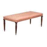 A MAHOGANY FRAMED AND UPHOLSTERED LONG STOOL IN REGENCY STYLE