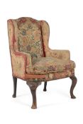 A WALNUT AND NEEDLEWORK UPHOLSTERED WING ARMCHAIR IN GEORGE II STYLE