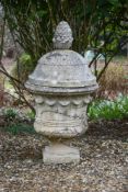 A STONE COMPOSITION GARDEN URN AND COVER