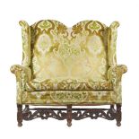 A WALNUT AND UPHOLSTERED WING BACK SOFA IN WILLIAM & MARY STYLE