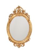 A VICTORIAN GILTWOOD AND COMPOSITION OVAL WALL MIRROR