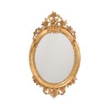 A VICTORIAN GILTWOOD AND COMPOSITION OVAL WALL MIRROR