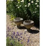 A PAIR OF STONE COMPOSITION GARDEN URNS