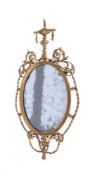 A GEORGE III CARVED GILTWOOD OVAL WALL MIRROR, IN THE MANNER OF JOHN LINNELL, CIRCA 1785