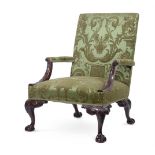 A CARVED MAHOGANY AND UPHOLSTERED GAINSBOROUGH ARMCHAIR, IN GEORGE II STYLE