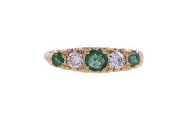 AN EMERALD AND DIAMOND FIVE STONE RING