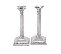 A PAIR OF SILVER CORINTHIAN CANDLESTICKS