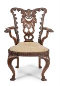 A CARVED MAHOGANY OPEN ARMCHAIR, IN GEORGE II STYLE, LATE 19TH/EARLY 20TH CENTURY