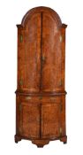 A GEORGE I MULBERRY AND FEATHER BANDED BOWFRONT STANDING CORNER CUPBOARD, CIRCA 1720