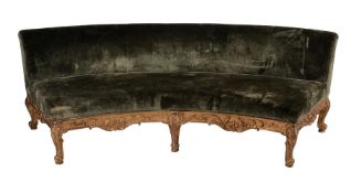 A CURVED GILTWOOD AND UPHOLSTERED SOFA IN MID 18TH CENTURY STYLE