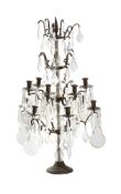 A CUT GLASS AND PATINATED METAL TWELVE LIGHT-CANDELABRA, IN THE MANNER OF MAISON JANSEN