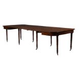 A REGENCY MAHOGANY AND PARCEL EBONISED EXTENDING DINING TABLE