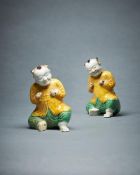 A pair of Chinese biscuit glazed models of seated smiling boys
