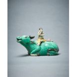 A Chinese biscuit glazed water dropper model of a boy seated on a buffalo