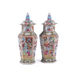 A pair of Chinese Canton export famille rose hexagonal vases and covers