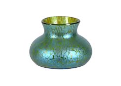 AN ART NOUVEAU IRIDESCENT GREEN GLASS VASE OF COMPRESSED FORM AND OF LOETZ TYPE