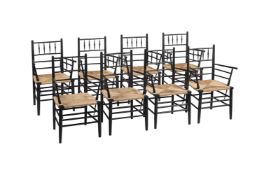 A SET OF EIGHT EBONISED AND RUSH ARMCHAIRS IN ARTS AND CRAFTS TASTE