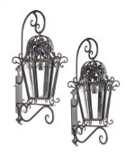 A PAIR OF BLACK PAINTED WROUGHT IRON EXTERIOR WALL LANTERNS