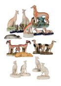 A GROUP OF FOUR CONTINENTAL BISCUIT PORCELAIN MODELS OF SEATED GREYHOUNDS