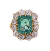 AN EMERALD AND DIAMOND CLUSTER RING