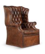 A BUTTONED LEATHER UPHOLSTERED WING ARMCHAIR, IN GEORGE III STYLE, 20TH CENTURY