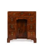 A GEORGE II WALNUT AND FEATHER BANDED KNEEHOLE DESK, CIRCA 1735