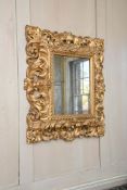 AN ITALIAN CARVED GILTWOOD WALL MIRROR, POSSIBLY FLORENTINE, FIRST HALF 18TH CENTURY