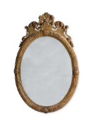 A QUEEN ANNE  CARVED GILTWOOD OVAL MIRROR, IN THE MANNER OF JEAN PELLETIER, CIRCA 1710