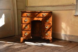 A GEORGE II WALNUT AND CROSSBANDED KNEEHOLE DESK, CIRCA 1730