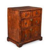 A GEORGE II WALNUT AND FEATHER BANDED MINIATURE CHEST OF DRAWERS, CIRCA 1735