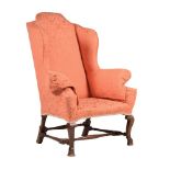 A WALNUT AND UPHOLSTERED WING ARMCHAIR IN WILLIAM & MARY STYLE