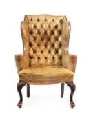 A WALNUT WING ARMCHAIR UPHOLSTERED IN GREEN LEATHER, IN GEORGE II STYLE, 20TH CENTURY