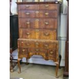 An early 18th century walnut tallboy with feather edged crossbandings upon Queen Ann legs.