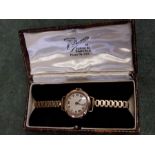 9ct gold cased ladies Rolls wristwatch with gold plated bracelet, working 15 jewel movement.