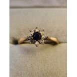 8ct yellow gold engagement ring mounted with central sapphire and 8 surrounding diamonds.