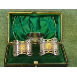 Cased pair of pierced rim silver napkin rings by Roberts & Belk, Sheffield 1896 and a floral