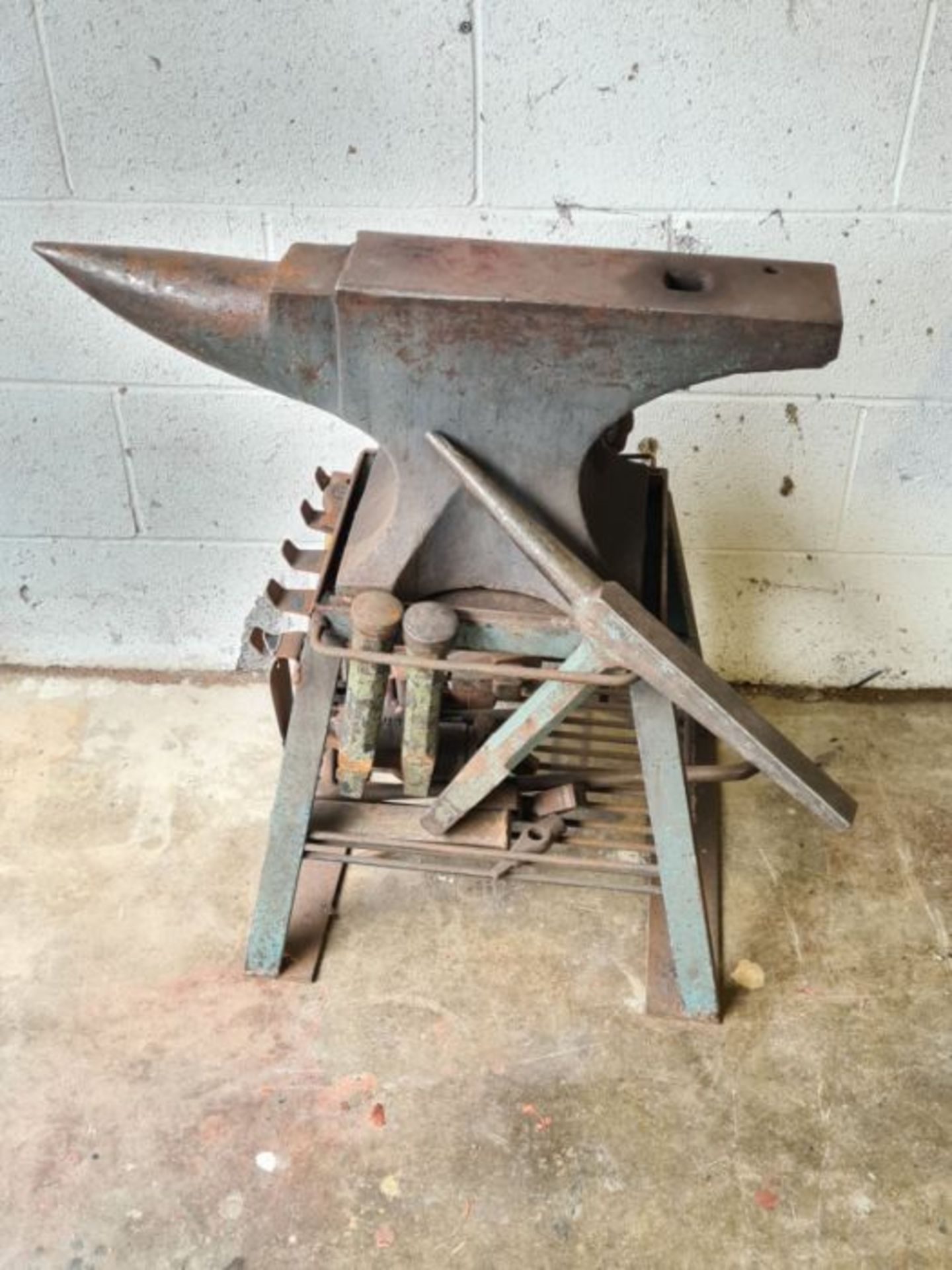 Medium size Blacksmiths anvil on stand and associated tools.