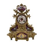 A late-19th century French mantle clock in a gilt spelter case surmounted with a hand painted porcel
