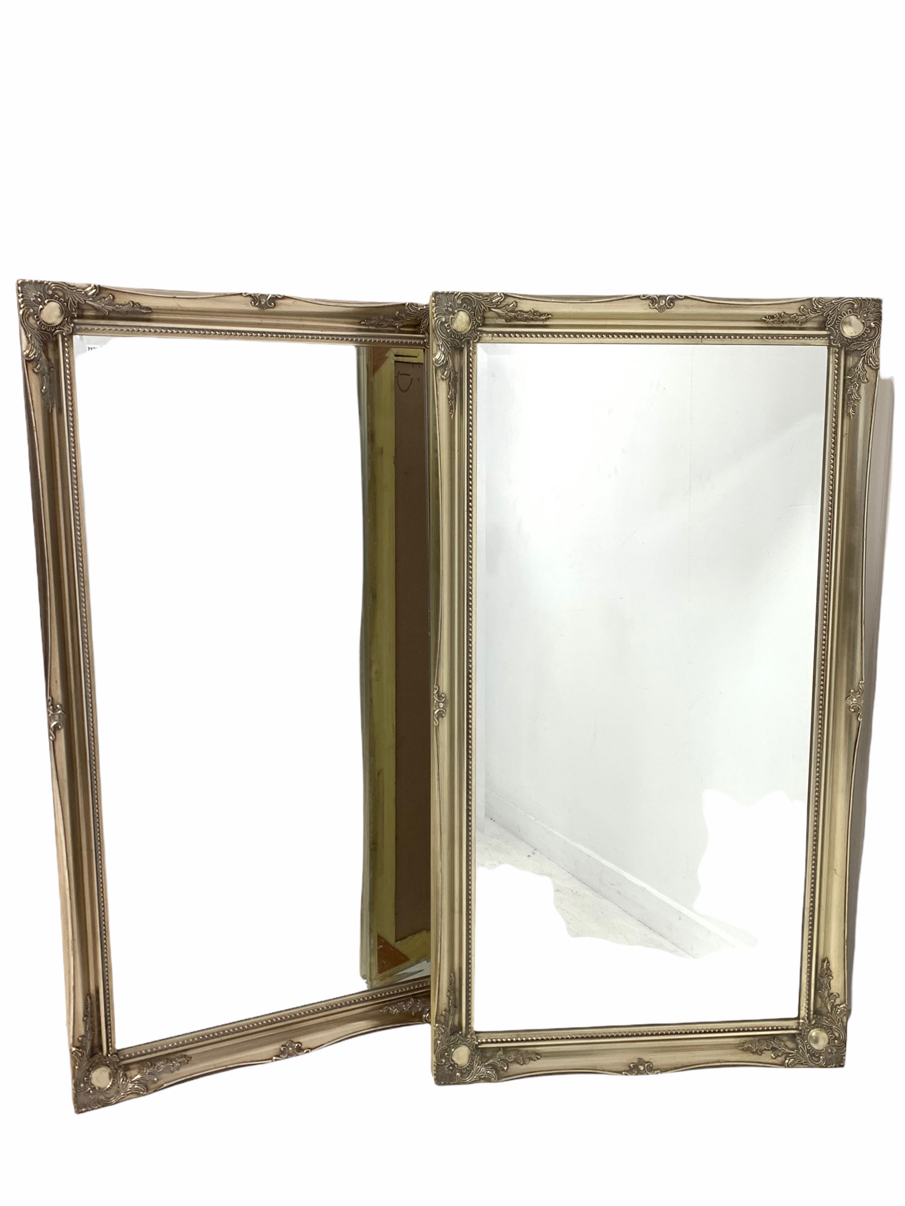 Pair of bevel edged wall mirrors in a swept silver gilt floral moulded frames 75cm x 137cm