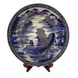 Japanese blue and white charger decorated in blue and gilt with Pagodas in a mountainous landscape
