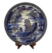 Japanese blue and white charger decorated in blue and gilt with Pagodas in a mountainous landscape