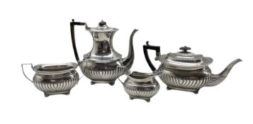 Silver three piece tea set with embossed half body decoration