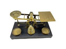 Set of Sampson Mordan & Co postal scales on ebonised plinth with brass weights