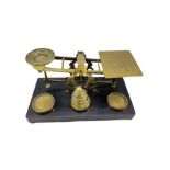 Set of Sampson Mordan & Co postal scales on ebonised plinth with brass weights