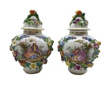 Pair of early 20th century Dresden porcelain floral encrusted vases and covers